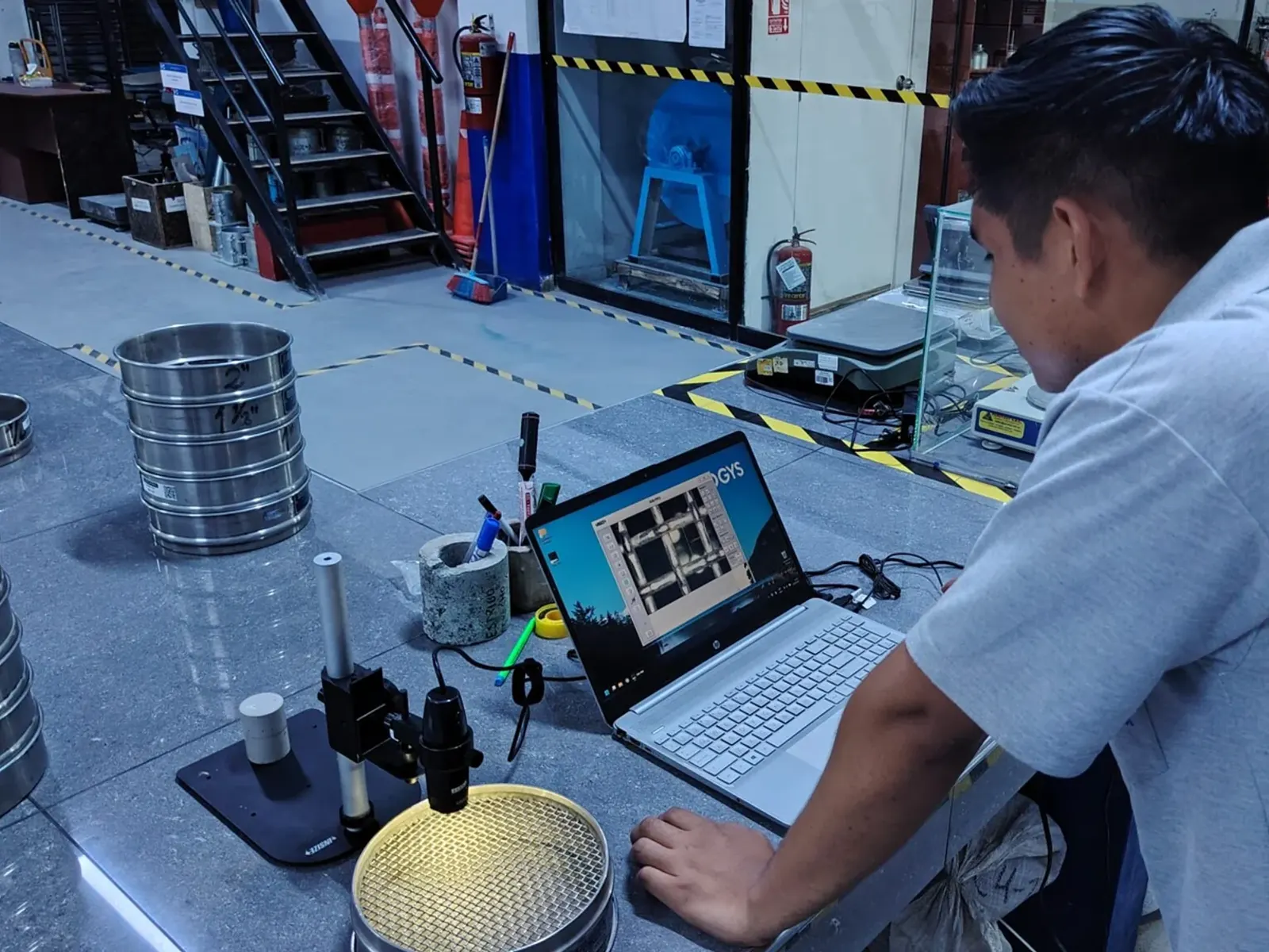 Técnico verificando un equipo del laboratorio con instrumentos de medición conectados.